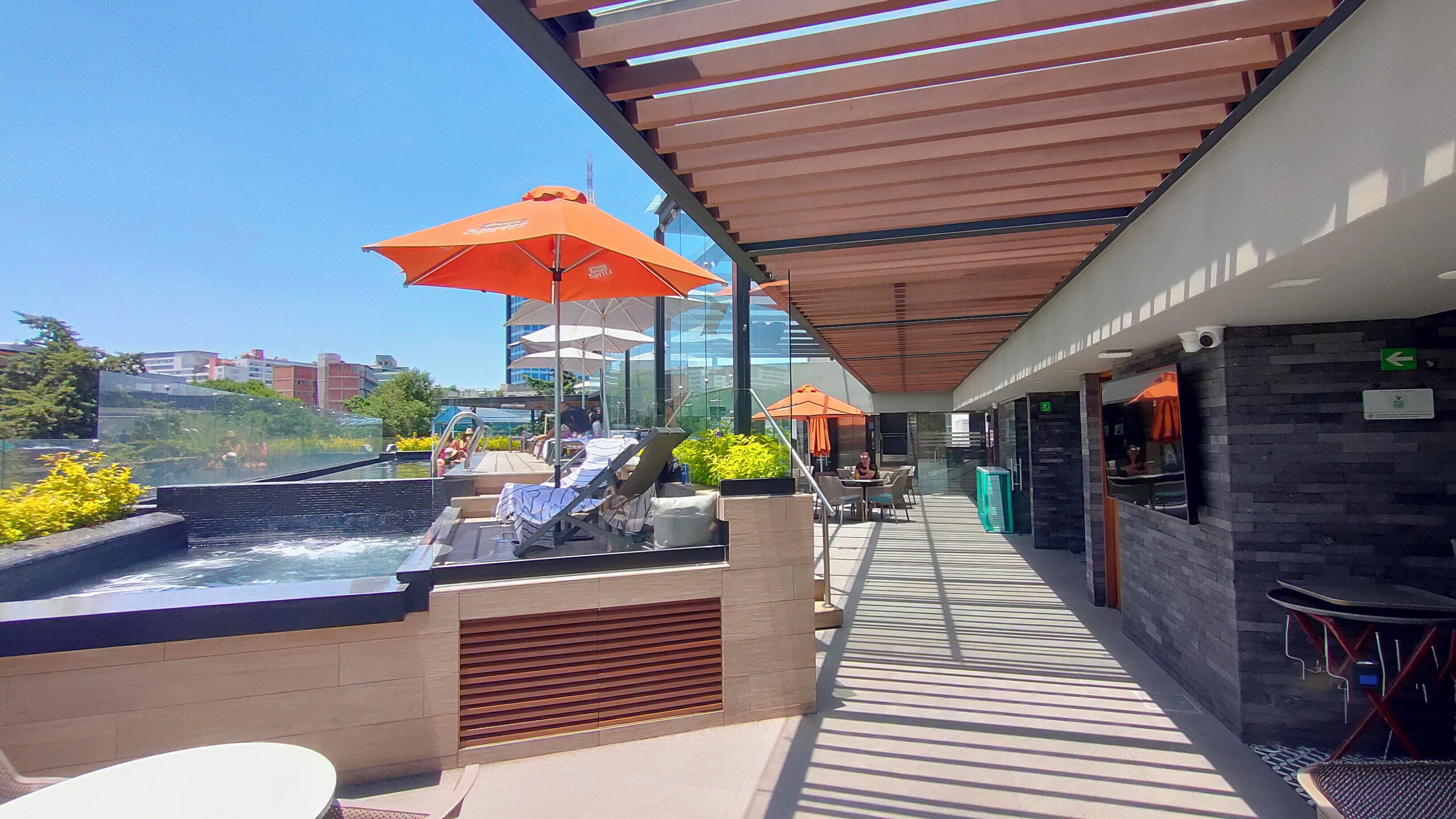 Alberca al aire libre, sombrillas en la alberca y camastros 