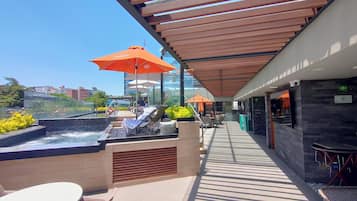 Alberca al aire libre, sombrillas en la alberca y camastros