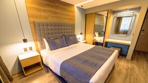 A modern bedroom with a large bed, wooden headboard, bedside tables, and a mirror. - Alia Inn Boutique WTC (Mexico City)
