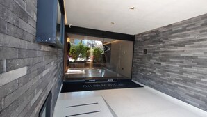 A modern hotel entrance with a glass door, a black threshold, and a tiled floor. - Alia Inn Boutique WTC (Mexico City)