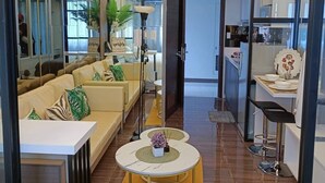 Un salon moderne comprenant un canapé, une table basse et un coin repas avec un bar.