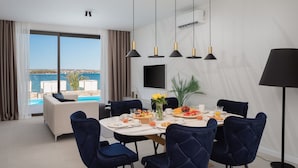 Een eetgedeelte met een tafel voor vier personen, een bank en uitzicht op zee.
