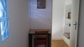 A small room with a wooden desk, a chair, a framed picture on the wall, and a bookshelf. - Town house in the heart of a typical Lot village (Saint-Sozy)