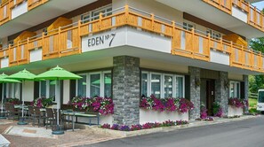 Un hotel con terraza al aire libre, pilares de piedra y balcones de madera.