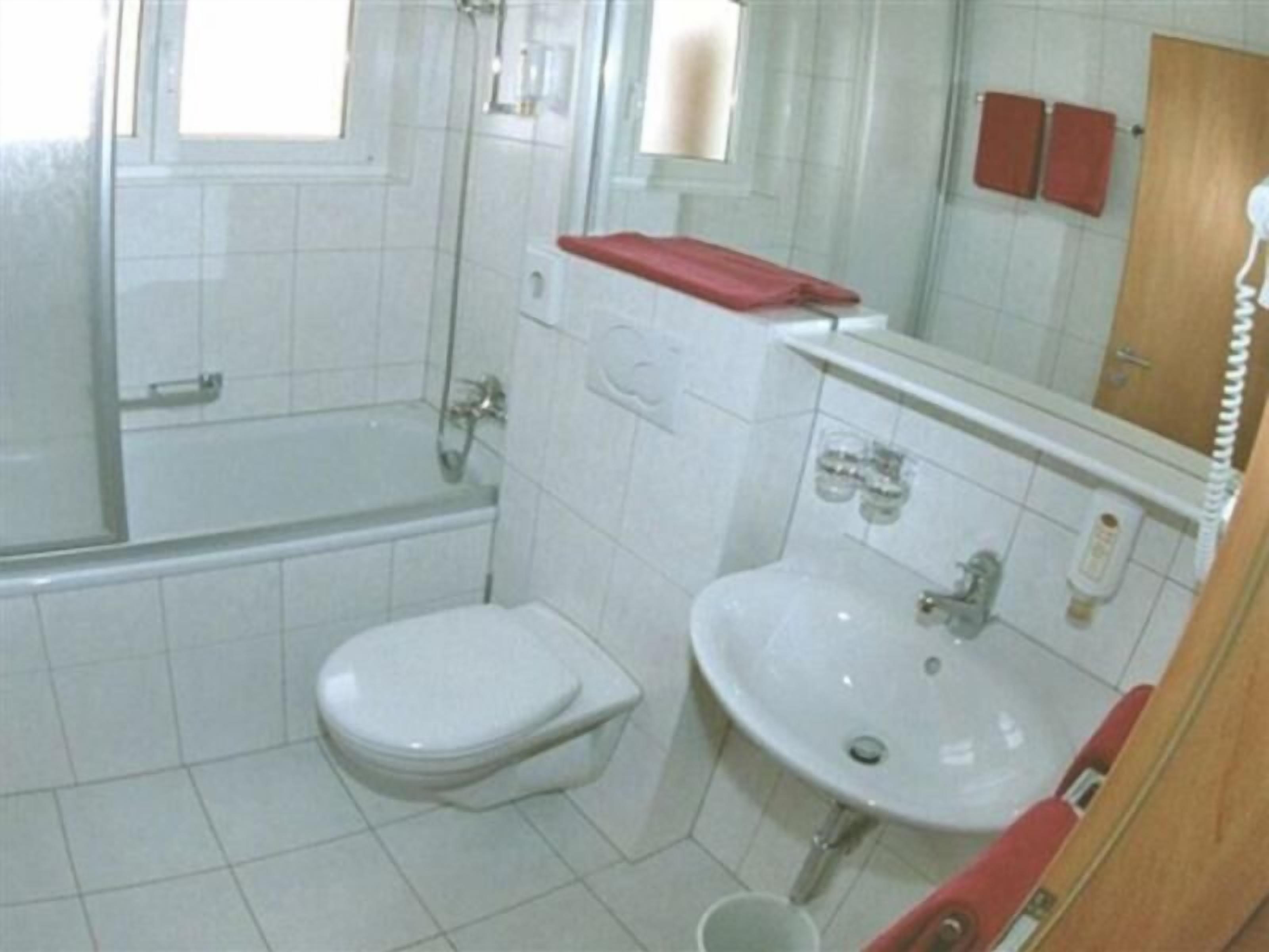 Une petite salle de bain avec des toilettes, un lavabo et une douche.