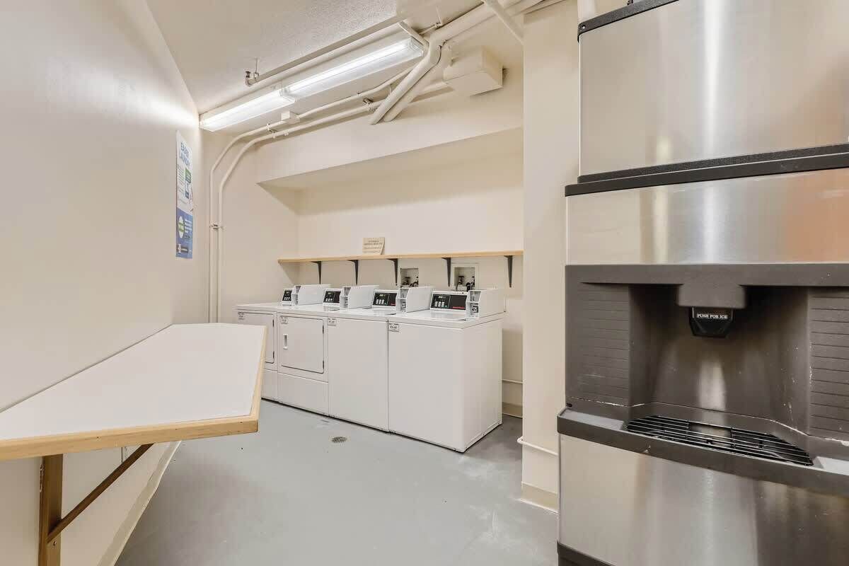 A laundry facility with multiple washing machines and a water dispenser.