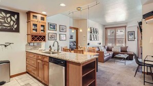 A compact kitchen with wooden cabinets, a dishwasher, and a granite countertop.