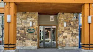 A hotel entrance with a stone facade, a glass door, and a sign that reads "Copper One."