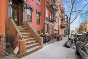 Stroll through a historic neighborhood lined with multi-story buildings and fire escapes.