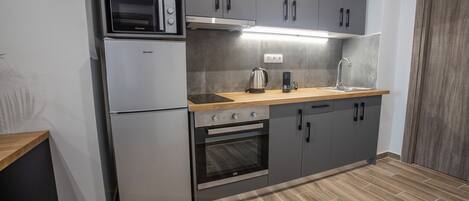Departamento Deluxe | Cocina privada | Refrigerador con congelador, microondas, horno y parrilla de estufa