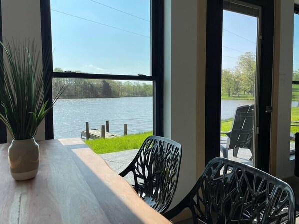 Enjoy a serene view of the lake and surrounding greenery from this room's large window.