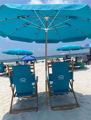 Relax under a shaded umbrella with ocean views.