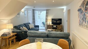 Una sala de estar moderna con un sofá, un televisor y una mesa con una vela.