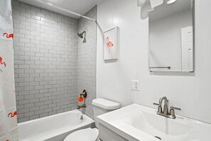 Ein modernes Badezimmer mit weißen Sanitärobjekten, einer Dusche und einem WC.