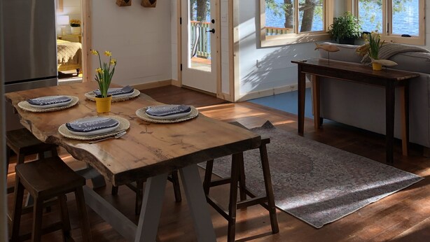 Een ruime keuken met een houten tafel, een koelkast en uitzicht op het omliggende landschap.