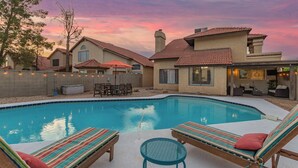 A backyard with a swimming pool, lounge chairs, and a patio area. - Your Home Away! Offering free heated pool ! Close to almost everything! (Chandler)