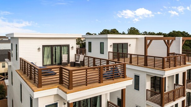 A modern multi-story building with wooden balconies and large windows. - Modern Single Family Home 5 minute walk to the Beach! Linens Included! (Carolina Beach)