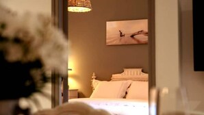 Una camera da letto con un letto, un comodino, una lampada e un quadro appeso al muro.