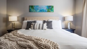 A neatly made bed with a beige blanket, two bedside lamps, and a painting above the bed. - Bright Centrally located home in Sedona (Sedona)