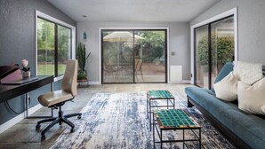 A modern living room with a desk, office chair, sofa, and a patterned rug. - Bright Centrally located home in Sedona (Sedona)