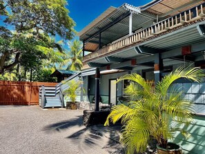 A two-story building with a balcony, a staircase, and a small porch area.