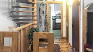 A wooden staircase leading to a kitchen with a view of the living area. - Reverse level cottage in Newlyn stunning sea views from the roof top balcony. (Newlyn)