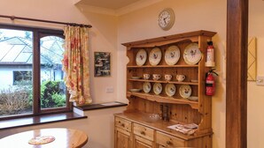 Una cocina con armarios de madera, un reloj y un extintor.