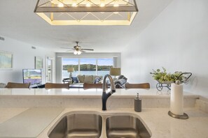 Una cocina moderna con un lavamanos doble, un ventilador de techo y vistas a un lago.