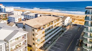 Un hôtel à plusieurs étages doté de balcons donnant sur une plage.