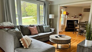 A living room with a grey sectional sofa, a round coffee table, and a fireplace. - Lake Front Haven with Dual Living Rooms, Hot Tub (Mt. Juliet)