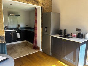 A compact kitchen with a refrigerator, stove, and sink.