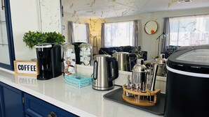 A kitchen with a coffee station, including a coffee maker, jars, and a kettle.