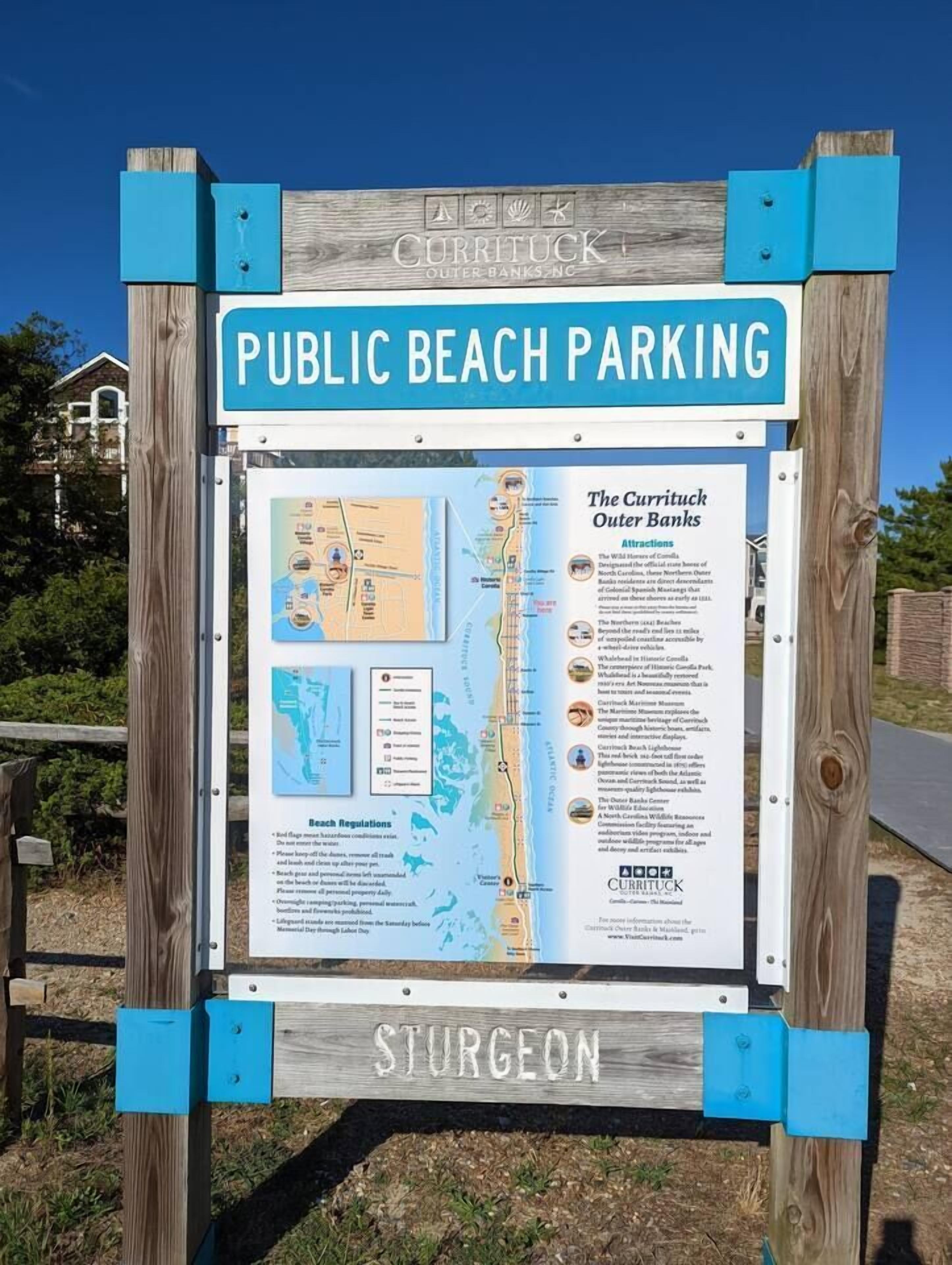 Un panneau d’information indiquant les emplacements de stationnement publics près de la plage et les attractions touristiques de Currituck Outer Banks.