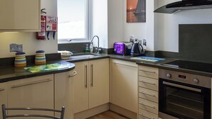 A compact kitchen with a window, a toaster, a kettle, and a stove. - Pennti Treth - UK39455 (Porth, near Newquay)