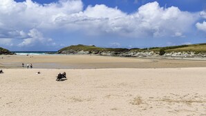 A wide sandy beach with gentle hills in the background and a clear sky. - Pennti Treth - UK39455 (Porth, near Newquay)