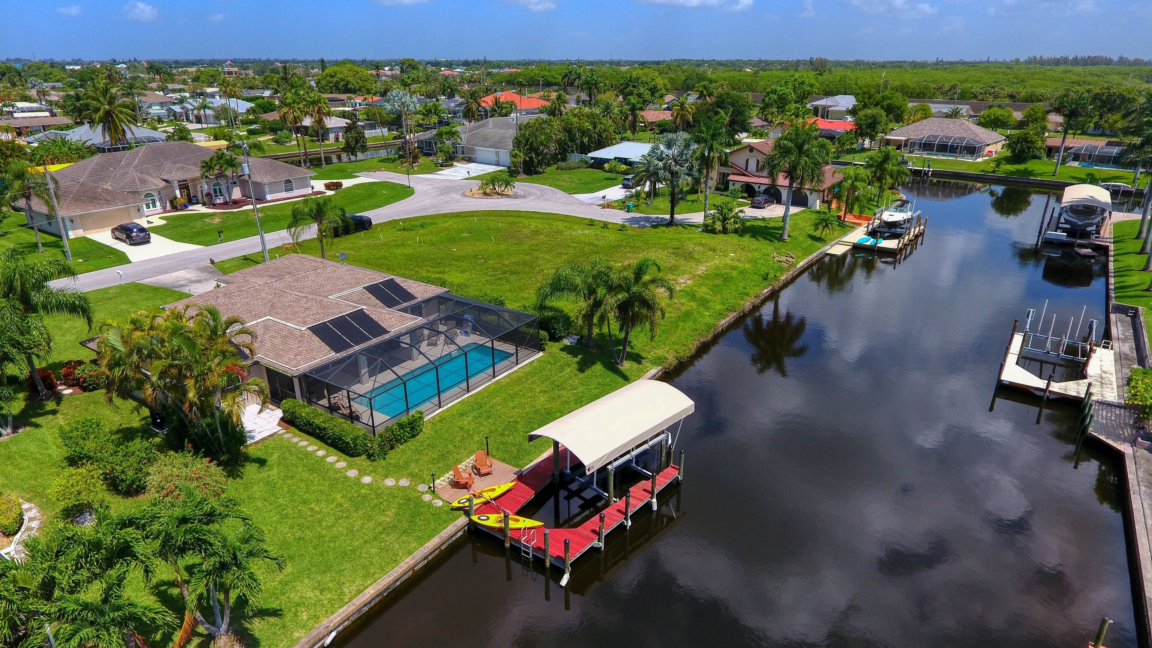 Zona residencial con piscina, muelle techado para barcos y un canal.