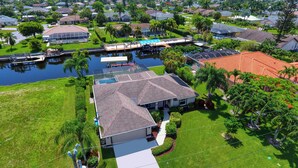 An aerial view of a residential area with houses, a swimming pool, and a dock.