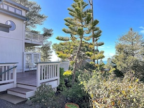 A two-story building with a balcony, surrounded by dense vegetation and a clear sky. - 2620 Merlyn Ave. Lodge Hill (Cambria)