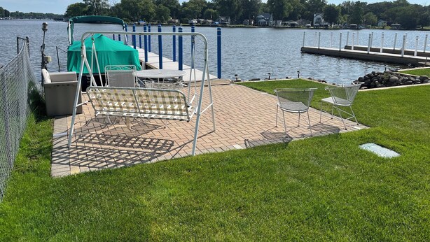 Une terrasse au bord de l’eau, avec des sièges extérieurs et une vue sur le lac.