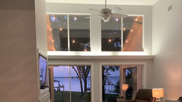 Un salón espacioso con techo alto, ventanas amplias y vistas al exterior.