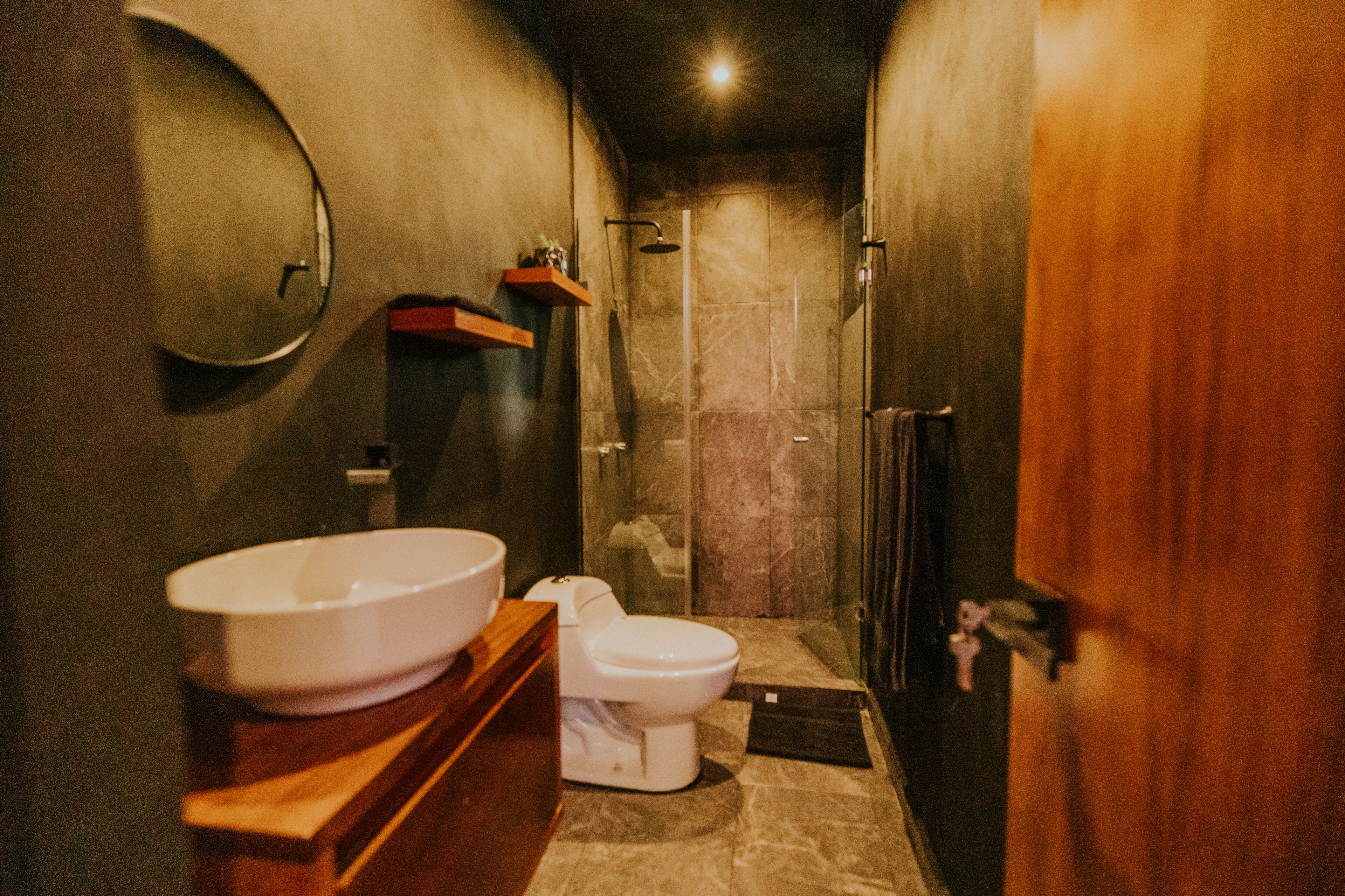 Een kleine badkamer met wastafel, toilet en douche.