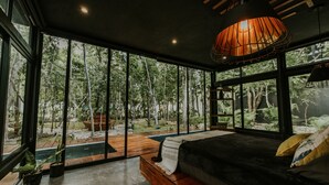 Une chambre à coucher moderne avec une grande fenêtre, un lit et un banc en bois.