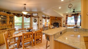 A spacious kitchen with wooden furniture, a granite countertop, and a fireplace. - 'Moose Lodge' Cabin w/ Entertainment Gazebo! (Baring)