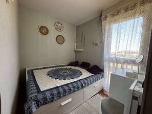 Une chambre à coucher avec un lit, un bureau doté d’un miroir et des éléments de décoration murale.