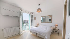Ein Schlafzimmer mit einem Bett, Nachttischlampen, einem Fenster und einer Heizung.