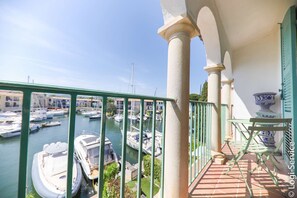 Un balcon offrant une vue sur une marina, avec des bateaux et un ciel dégagé.