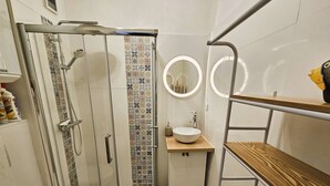 Une petite salle de bain comprenant une douche, des toilettes et un lavabo.
