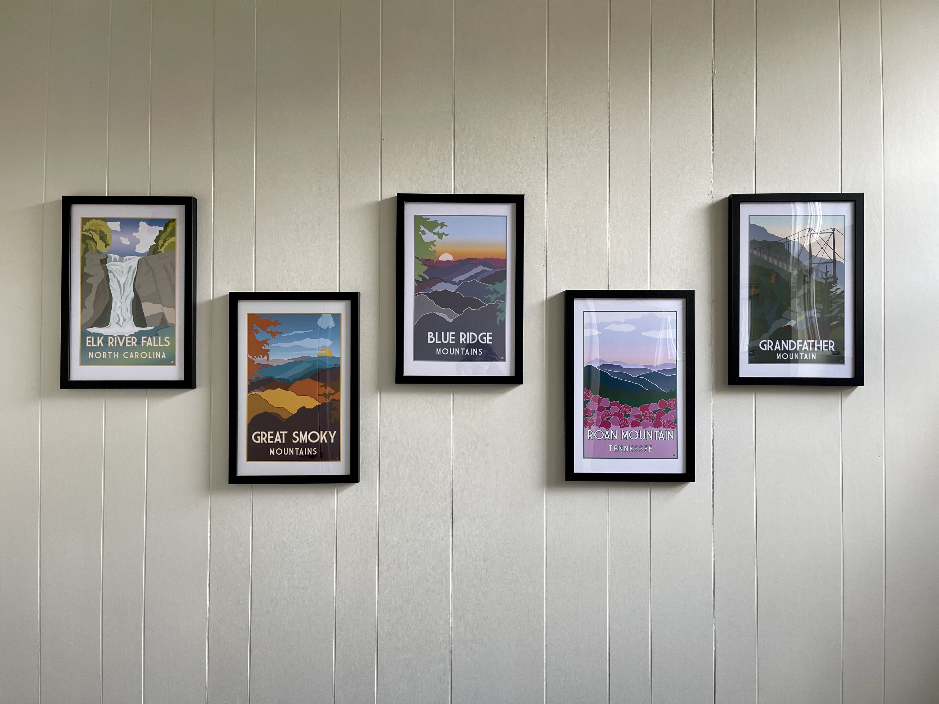 Five framed posters on a wall.