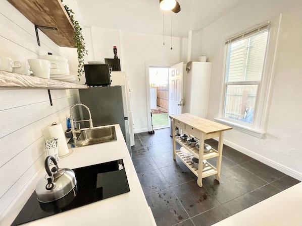 Enjoy cooking in this well-equipped kitchen with a stainless steel sink, refrigerator, and microwave.