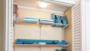 Vaatehuone, jossa on hyllyjä, säilytyslaatikko ja ripustettavia säilytyspusseja.